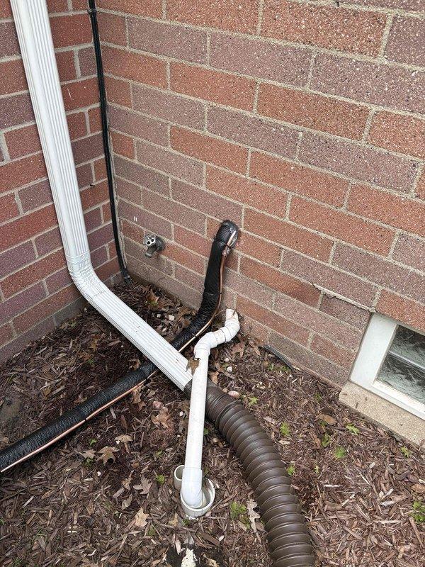 Successfully completed add-on air conditioning installation to existing Carrier furnace system in basement mechanical room. Installed new air handler unit adjacent to existing heating equipment, integrated cooling coil with furnace plenum, and connected metallic supply ductwork. Ran refrigerant line set from basement through exterior wall to outdoor condensing unit location at building foundation. Established proper drainage routing utilizing existing downspout system and corrugated drain lines. Completed all electrical connections, tested system operation, verified proper airflow and refrigerant charge, and confirmed integration with existing HVAC controls for seamless heating and cooling functionality.