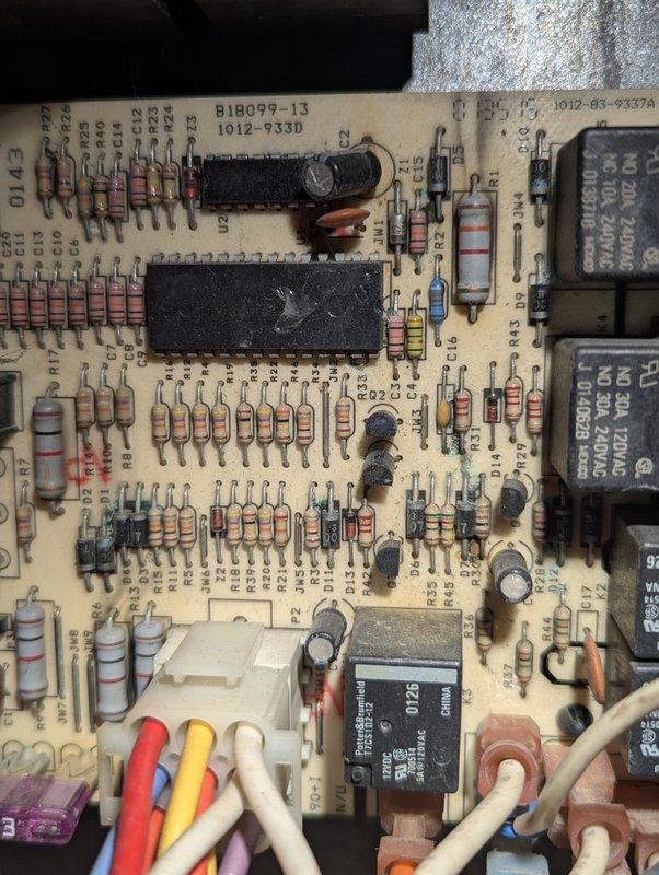 Responded to service call for 22-year-old Goodman heating system with reported thermostat issues and incomplete cycling. Customer had recently replaced thermostat batteries, but indoor fan would not activate and system failed to complete full heating cycles. Upon arrival, performed diagnostic evaluation of control board and electrical components. Inspection revealed aging furnace control board with visible signs of wear, dust accumulation, and potential corrosion near solder joints affecting circuit integrity. Documented control board condition with photos showing component degradation on PCB including resistors, capacitors, relays, and integrated circuits. Identified control board as likely source of intermittent operation and fan relay malfunction preventing proper system cycling. Provided customer with findings and repair recommendations for control board replacement to restore reliable heating system operation.