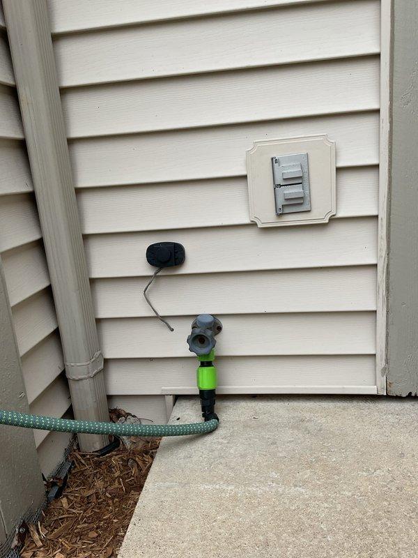 Installed a Groundwork 3/4 inch brass dual hose connector with individual shutoff valves on outdoor faucet to provide dual water access points. The Y-connector features independent control levers for each outlet, allowing simultaneous use of multiple hoses or accessories while maintaining individual flow control.