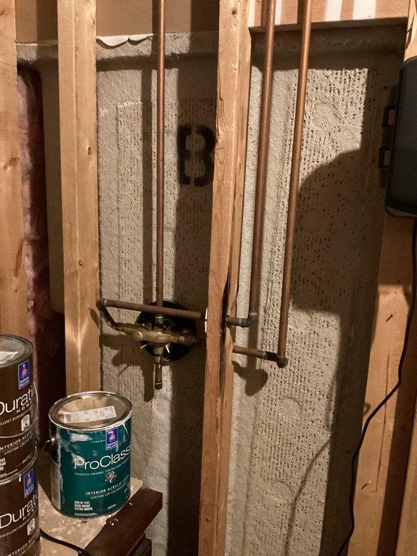 Completed comprehensive plumbing project estimate for bathroom remodel involving exposed copper piping installation within framed wall cavity with spray foam insulation, and assessment of existing shower enclosure featuring dark bronze framed glass sliding doors with white acrylic surround. Documented all plumbing infrastructure, wall framing conditions, and finished bathroom fixtures to provide accurate scope and specifications for proposed renovation work.