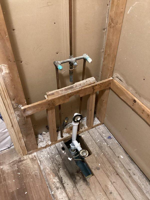 Completed installation of client-supplied bathtub and shower fixtures in active renovation space. Rough-in plumbing connections were established with galvanized supply lines, compression fittings, and PVC drain assembly through floor framing, followed by fixture mounting and trim work. All plumbing components were installed per code with proper access maintained for future service.