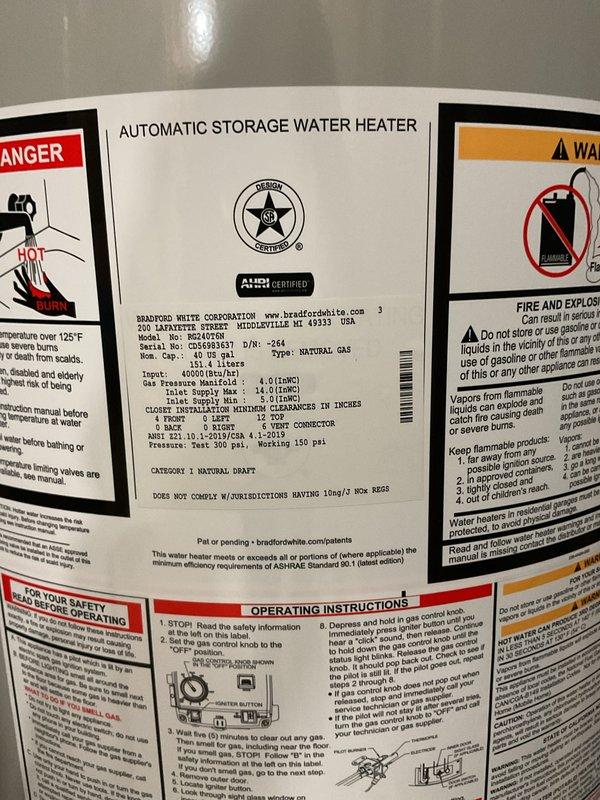 Completed installation of a 40-gallon natural gas Bradford White water heater in residential utility space. Unit was properly positioned, connected to existing copper supply lines with brass fittings and shut-off valves, vented with appropriate flue piping, and installed per manufacturer specifications and local code requirements.