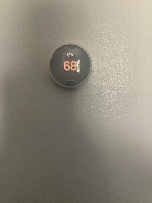Returned to address no heat condition on 16-year-old Goodman furnace following previous day's service call for noise issues. Upon arrival, found Nest thermostat displaying low battery warning and shutting down to recharge, preventing heat call to furnace. Allowed thermostat battery to recharge, restored power to device, and verified proper communication between thermostat and heating system. Confirmed furnace operation and heat delivery, with thermostat successfully calling for and maintaining 68° setpoint.