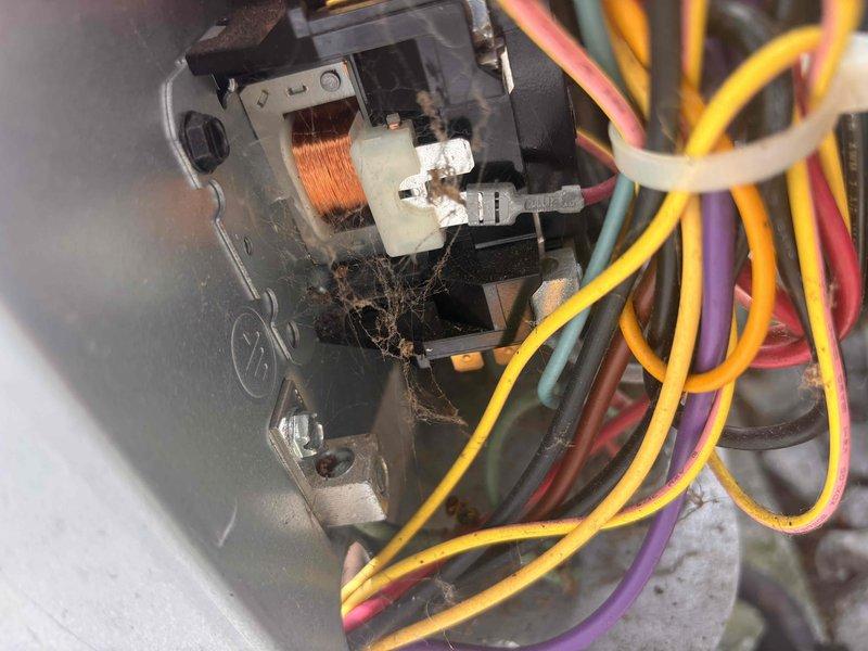 Responded to no cooling complaint on residential AC unit. Upon inspection, found contactor heavily contaminated with spider webs and debris causing failure to energize compressor. Cleaned contactor assembly, removed all cobwebs and buildup from electrical connections, verified proper voltage at unit, and tested system operation. Unit now cooling properly with contactor engaging as designed.