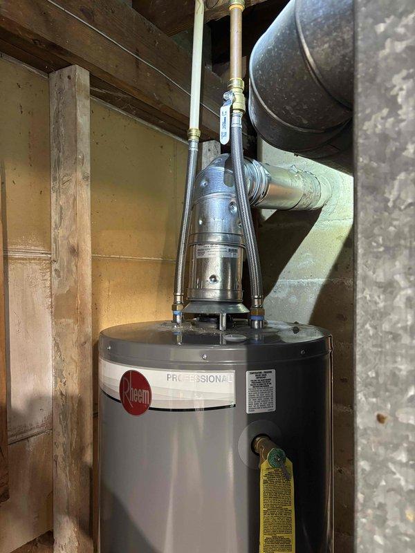 Corrected water heater venting installation to meet code requirements by relocating new vent pipe to maintain proper clearance from SharkBite flexible water connectors. Repositioned metallic ductwork and secured with appropriate hangers and strapping to wooden ceiling joists, ensuring adequate separation between venting system and plumbing connections as required by municipal inspection standards.