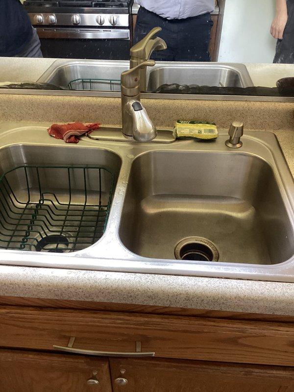 Completed sales estimate for plumbing project involving installation of new toilet, two new faucets, and garbage disposal. Assessed existing kitchen sink setup with double-basin stainless steel configuration, current single-handle faucet, and inspected under-sink plumbing including existing garbage disposal unit and PVC drain assembly with P-trap configuration. Documented current conditions and provided estimate for requested plumbing upgrades.