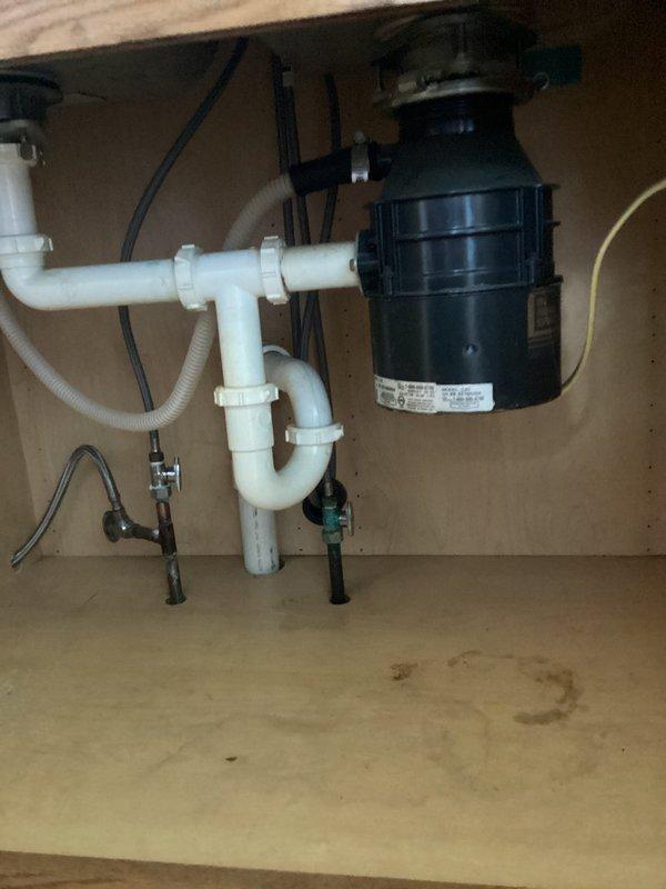 Completed sales estimate for plumbing project involving installation of new toilet, two new faucets, and garbage disposal. Assessed existing kitchen sink setup with double-basin stainless steel configuration, current single-handle faucet, and inspected under-sink plumbing including existing garbage disposal unit and PVC drain assembly with P-trap configuration. Documented current conditions and provided estimate for requested plumbing upgrades.