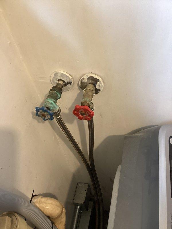 Responded to service call for washing machine water supply lines installed in reverse configuration. Upon arrival, identified that hot and cold water shut-off valves were connected opposite to standard plumbing convention, with hot water line on right side instead of left. Verified issue by inspecting wall-mounted valves with turquoise and red wheel handles and tracing supply connections. Corrected the cross-connection by properly reconnecting the flexible stainless steel braided supply hoses to appropriate hot and cold water sources, ensuring hot water feeds to left connection and cold water to right connection per industry standard. Secured all connections and verified proper water flow to washing machine. System tested and operating correctly with water lines now properly configured.