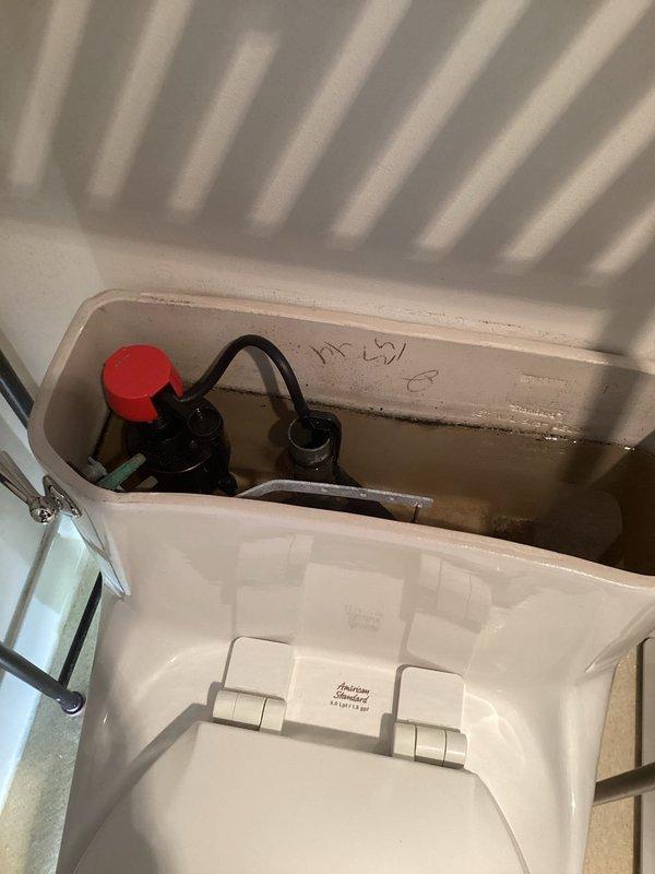 Responded to service call for toilet issues in two bathrooms of a 1960s-era home where problems had been progressively worsening over the previous week. Upon inspection, found aging flush mechanisms with mineral buildup and deteriorating internal components in both units. Removed tank lids to access and evaluate fill valve assemblies, flush valves, and flapper mechanisms. Observed significant discoloration and mineral deposits on interior tank surfaces indicating water quality issues and component wear. Documented existing float ball system and flush valve configuration with black rubber flapper showing signs of deterioration. Inspected chrome flush handles and associated linkage for proper operation. Photographed internal tank conditions and component configurations for service records. Assessed both toilets for proper water fill levels, flapper seal integrity, and flush performance. Completed necessary repairs or replacements to restore proper flushing function in both bathrooms.