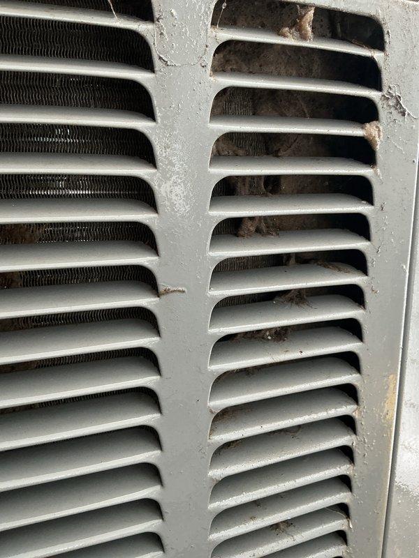 Completed comprehensive ASTU-AC Super Tune-up service on a 7-year-old EnergiAir unit with warranty extending to June 2028. Performed thorough inspection of outdoor condenser unit, documenting significant dust and debris accumulation on ventilation grilles and heat exchanger fins, along with visible oxidation and moisture presence on exterior louvers. Cleaned condenser coils, cleared obstructions from airflow passages, and verified proper system operation to maintain warranty compliance and optimize cooling efficiency.