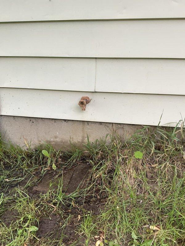 Responded to reported thumping noise occurring during toilet flushing and high water usage. Inspected basement plumbing infrastructure and identified water hammer issue in drainage system. Examined exposed PVC piping and support brackets in crawl space to assess pipe movement and securing points. Replaced deteriorated outdoor hose spigot that exhibited active leaking and corrosion. Removed old copper fixture from exterior wall and installed new frost-free sillcock with proper mounting and sealing to prevent future leaks.