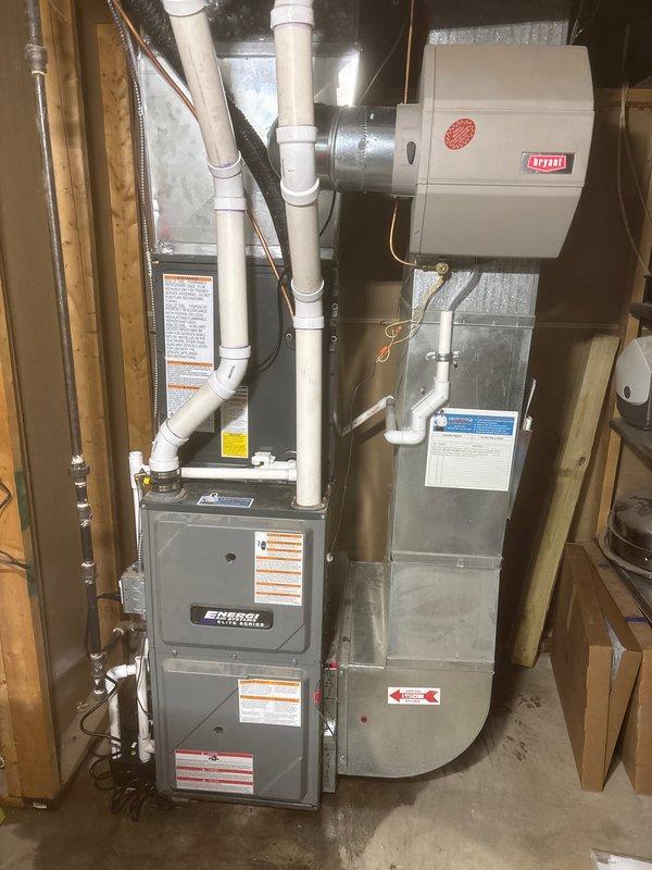 Completed full HVAC system replacement including installation of new forced-air furnace with integrated humidifier unit in basement utility area. Installed new outdoor condensing unit with proper refrigerant charge verification showing factory charge of 53.4 oz with total system charge of 53.4 oz. All refrigerant lines properly insulated and connected with brass service valves, PVC condensate drainage installed, and system tested for proper operation upon completion.