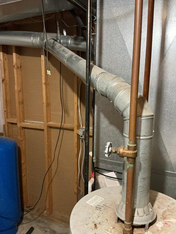 Responded to no hot water complaint affecting entire residence. Assessed existing 20-year-old water heater in basement utility area showing signs of age and deterioration, including visible rust staining on tank surface. Provided estimate for complete water heater replacement with professional installation, including removal of existing unit and proper connection of copper supply lines, venting system, and electrical components.