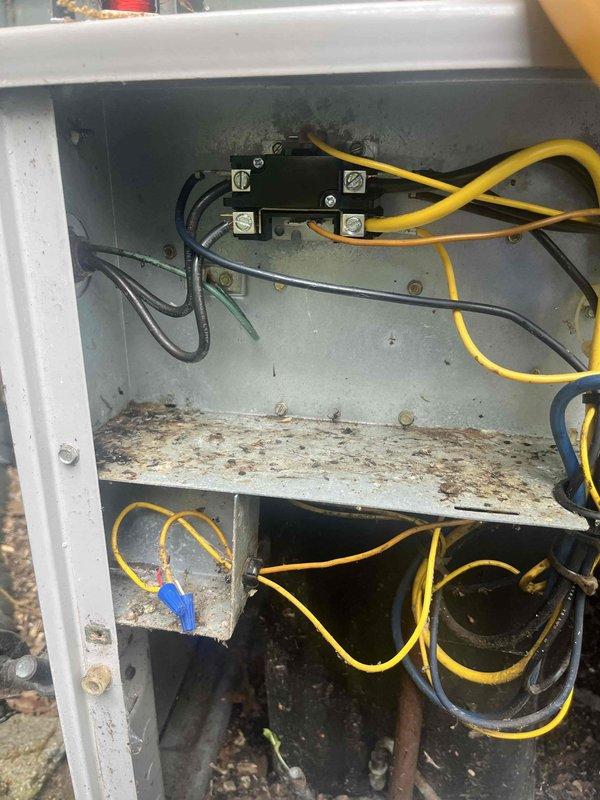 Responded to no cooling call on 2020 HVAC system. Upon arrival, confirmed entire system was not operational. Inspected outdoor unit electrical components and found heavy dirt accumulation, debris buildup, and corrosion throughout the control panel enclosure. Contactor and relay connections showed signs of environmental exposure with visible staining and weathering on interior surfaces. Documented equipment condition with photographs showing deteriorated electrical panel with rust spots, discolored surfaces, and compromised wiring connections. System required cleaning and electrical component evaluation to restore proper operation.