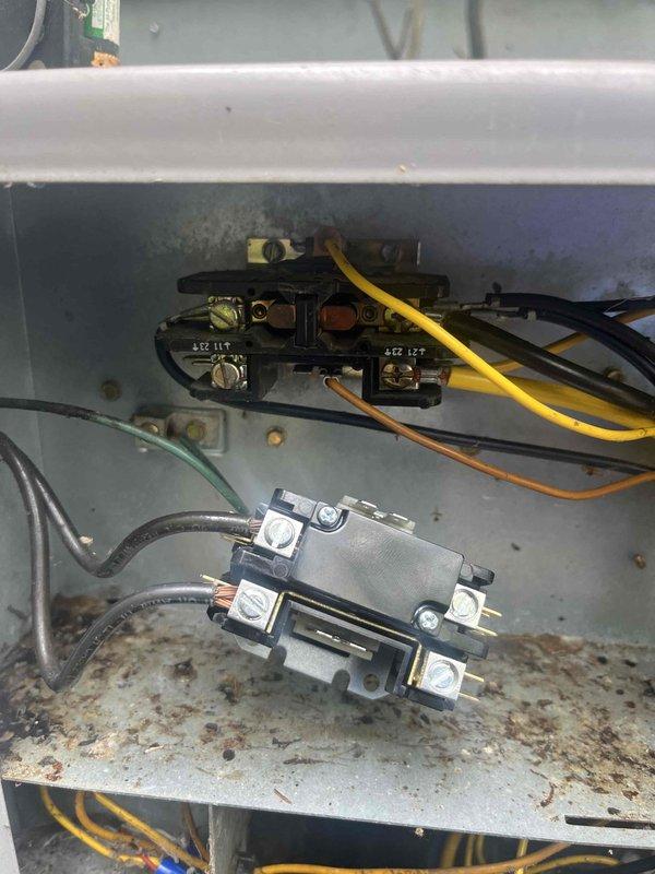 Responded to no cooling call on 2020 HVAC system. Upon arrival, confirmed entire system was not operational. Inspected outdoor unit electrical components and found heavy dirt accumulation, debris buildup, and corrosion throughout the control panel enclosure. Contactor and relay connections showed signs of environmental exposure with visible staining and weathering on interior surfaces. Documented equipment condition with photographs showing deteriorated electrical panel with rust spots, discolored surfaces, and compromised wiring connections. System required cleaning and electrical component evaluation to restore proper operation.