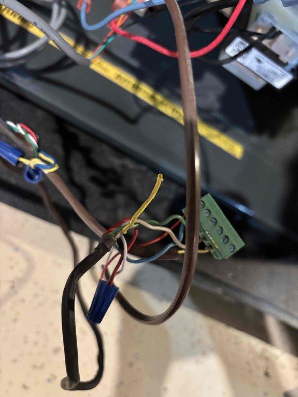 Responded to no-cool condition on 12-year-old Goodman air conditioning system affecting entire home. Upon inspection, identified faulty wiring connections at the unit's terminal block causing system failure to start. Repaired and secured all electrical connections including red, blue, yellow, and ground wires to terminal block, ensuring proper voltage delivery to compressor and fan circuits. Verified all wire terminations were tight and properly seated. Tested system startup and confirmed unit now operating normally with proper cooling restored to home.