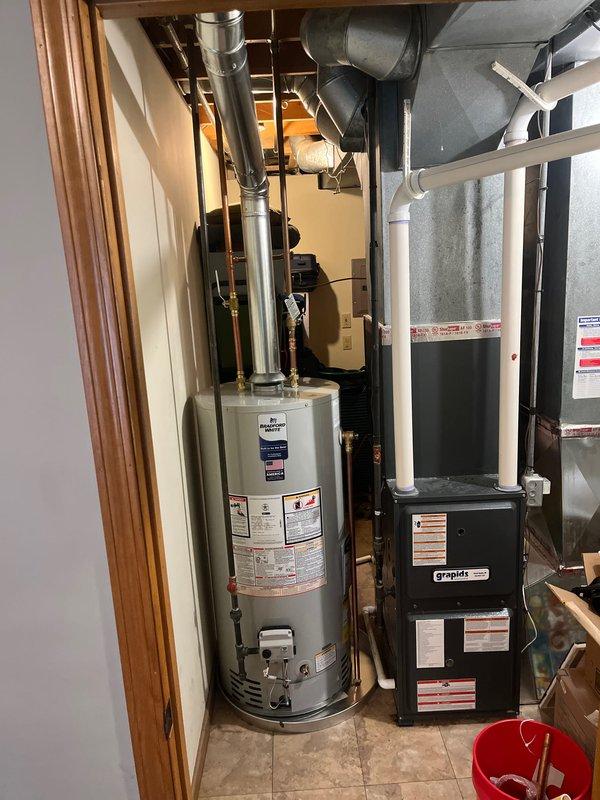 Successfully installed a 40-gallon natural gas water heater in the residential mechanical room. The unit was positioned alongside existing HVAC equipment with proper clearance for maintenance access. Connected metallic exhaust venting through the ceiling with secure mounting flange and proper sealing at all joints. Verified all gas connections, tested for leaks, and ensured proper draft operation through the venting system. Unit was filled, fired, and tested for proper operation with all safety controls functioning as designed.