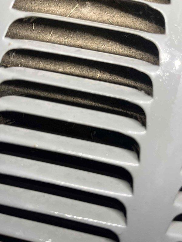 Completed comprehensive AC Super Tune-up on split system unit with 5-year energy efficiency service package. Performed full system inspection, cleaned evaporator coils visible behind white louvered grilles, verified proper airflow through ventilation components, and documented equipment condition with before/after photography showing clean, well-maintained grille assemblies and internal heat exchange components.