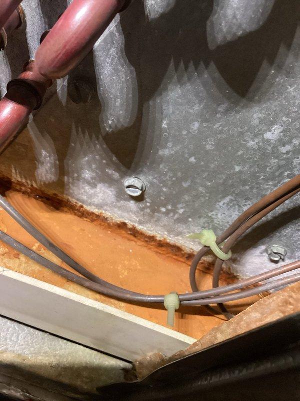 Completed annual cooling maintenance on 21-year-old Goodman AC system. Upon inspection, discovered evaporator coil completely frozen with heavy ice and frost buildup throughout the entire coil assembly. Identified airflow restriction as primary cause of freezing condition. Found dirty air filter (FilterBuy brand) requiring replacement. Shut down system to allow ice to thaw completely before proceeding with diagnostic testing. Inspected refrigerant lines and connections - copper lines intact with proper insulation. Checked electrical connections and wiring at control board - all secure with proper terminations. After ice melt, verified blower motor operation and airflow through system. Replaced air filter with new unit to restore proper airflow. Tested system operation after thaw cycle completed. Checked refrigerant pressures and system performance. System restored to normal operating condition with adequate airflow and no further freezing observed during test run.