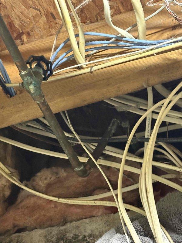 Completed annual cooling maintenance on a 9-year-old air conditioning system. Performed comprehensive tune-up including inspection of indoor and outdoor units, verified refrigerant levels, checked electrical connections, cleaned condenser coils, tested system operation and airflow, and documented equipment condition with photos of basement utility area and attic mechanical space showing electrical wiring, ductwork, and insulation.