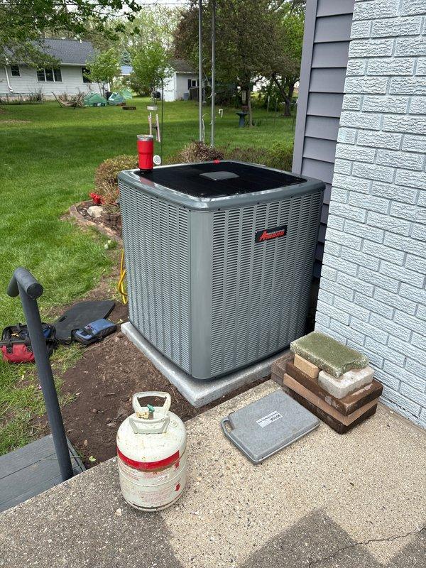 Completed full HVAC system replacement including outdoor condensing unit and indoor air handler. Removed existing equipment and installed new gray condensing unit on concrete pad with proper refrigerant line connections and electrical hookup. Installed new furnace/air handler in basement mechanical room with updated PVC venting system configured for proper exhaust and intake. Verified all refrigerant connections, tested system operation, and confirmed proper airflow throughout the system.