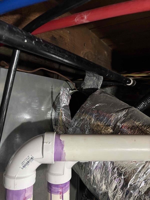 Responded to complaint of inadequate heating and cooling to upstairs area on recently installed EnergiAir system. Upon inspection of attic space, discovered extensive damage to flexible ductwork serving the upper level. The outer foil vapor barrier layer was severely torn and shredded in multiple locations, with insulation exposed and hanging loose from the main duct body. This compromised ductwork was allowing significant conditioned air loss before reaching the intended living spaces, resulting in poor temperature control upstairs despite the system operating normally. Documented the damaged ductwork conditions with photographs showing the deteriorated sections and compromised insulation integrity. The torn and peeling metallic outer layer indicated either installation damage or subsequent physical impact to the duct system. Recommended immediate ductwork replacement or repair to restore proper airflow delivery and system performance to the upstairs zones.