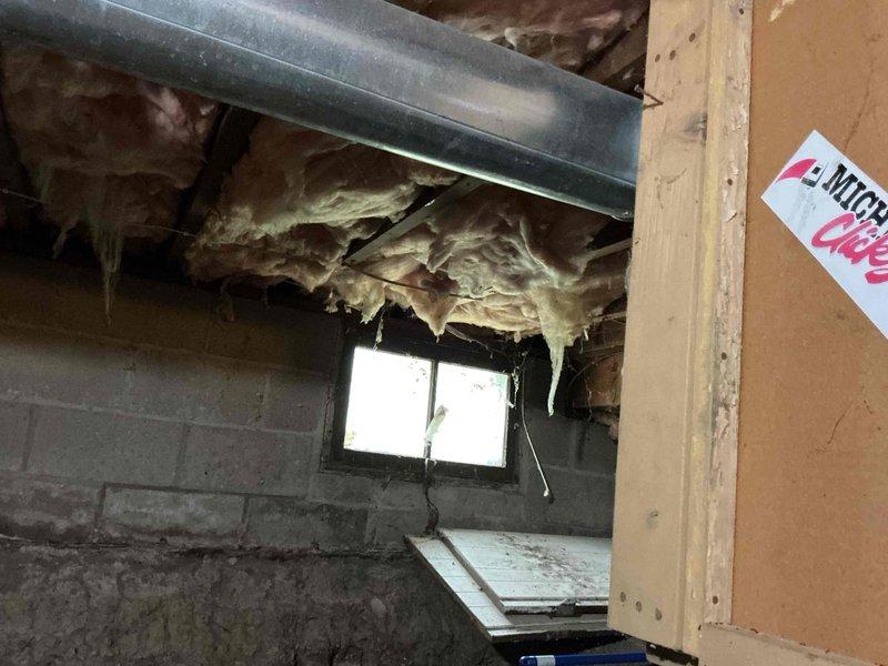 Conducted comprehensive plumbing project estimate for basement utility work including installation of new utility sink, replacement of deteriorated outdoor spigot, and assessment of additional minor plumbing tasks. Documented existing conditions showing aged copper piping with gate valves and water meter assembly in basement corner area with significant moisture damage to concrete block walls. Evaluated workspace constraints including exposed fiberglass insulation, HVAC ductwork, and limited access conditions typical of unfinished basement mechanical areas.