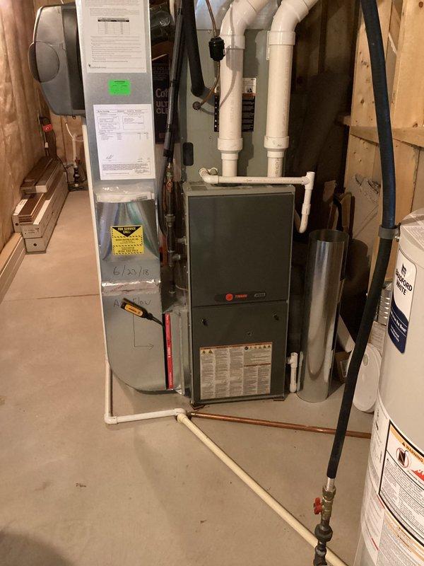 Responded to no cooling complaint affecting entire residence with 8-year-old system. Upon arrival, performed diagnostic evaluation of HVAC system including Trane furnace and air handler unit located in basement utility area. Inspected equipment connections, refrigerant lines, electrical components, and system controls to identify cause of cooling failure. Documented equipment condition and system configuration with photographs for service records.