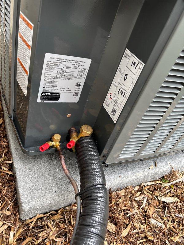 Successfully completed full air conditioning system replacement at residential property. Installed new condensing unit on existing concrete pad with proper electrical disconnect, refrigerant line connections using brass service valves with protective caps, and integrated PVC drainage system along foundation. All refrigerant lines properly insulated, system tested and verified operational, with unit positioned on stable pad surrounded by landscaped mulch bed for optimal airflow and drainage.