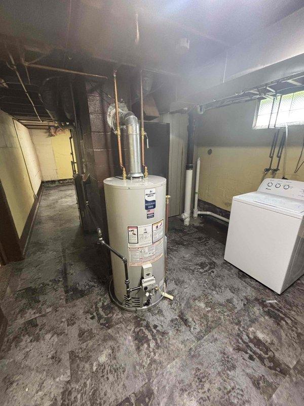 Successfully completed installation of a 40-gallon natural gas water heater in basement utility area. Removed existing unit and installed new short-height natural gas water heater with proper venting, copper supply line connections with brass fittings, and gas line hookup. All connections were secured and tested for proper operation and safety compliance.
