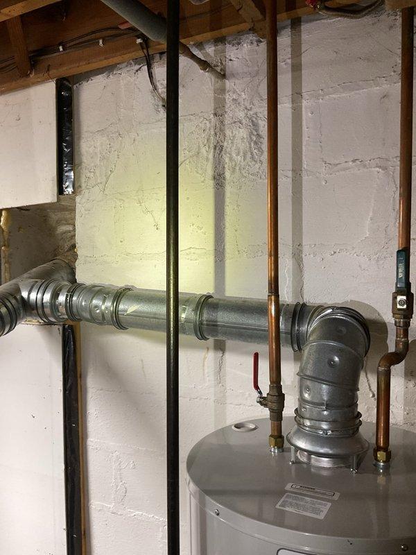 Responded to water leak from pressure relief valve on water heater. Upon arrival, confirmed active discharge from temperature and pressure relief valve on Bradford White replacement unit installed in 2020 with warranty expiration October 2033. Inspected water heater installation, associated copper piping connections, and surrounding plumbing system including pressure tank and dual water filtration housings. Documented existing conditions with photographs showing utility area setup, wall staining from previous moisture exposure, and complete mechanical room configuration. Assessed PRV operation and system pressure to determine cause of discharge and recommended appropriate corrective action to resolve leak condition.