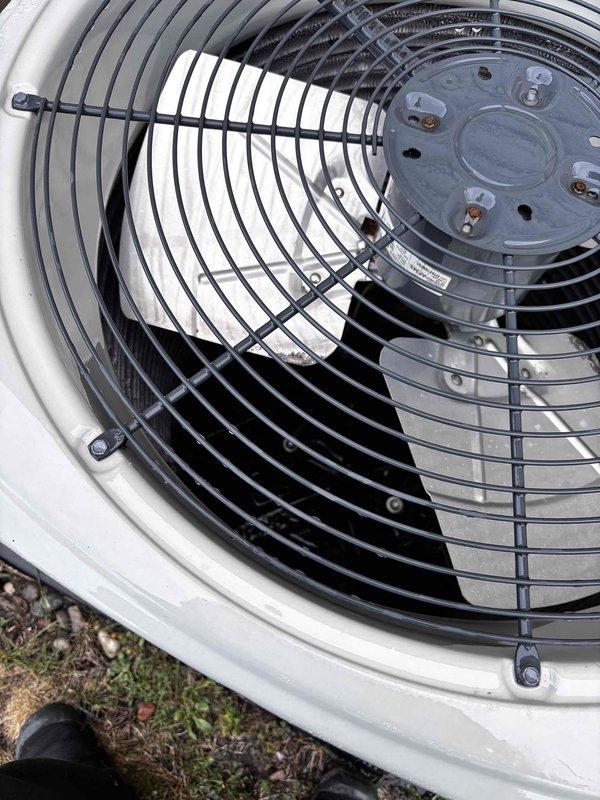 Completed annual cooling maintenance on 12-year-old Trane system. Inspected condenser unit and found debris accumulation including organic material and plant matter lodged between evaporator coils and refrigerant lines. Removed foreign material from interior cavity to restore proper airflow and prevent potential system efficiency loss. Verified fan motor operation, inspected fan guard assembly and housing integrity. All components found to be in functional condition following cleaning. System operational and ready for cooling season.