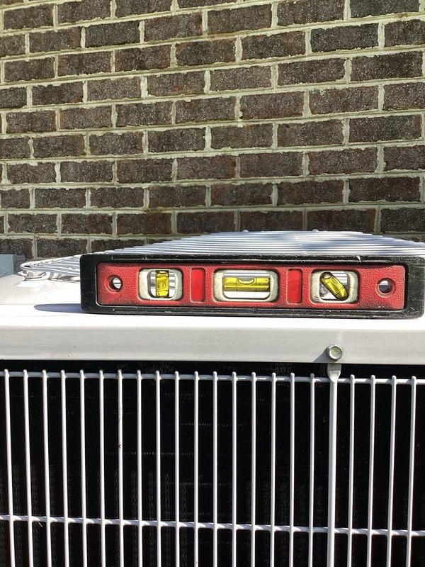 Completed annual cooling maintenance on 12-year-old Carrier air conditioning system. Performed comprehensive tune-up including inspection of outdoor condensing unit, verified proper leveling of equipment using precision tools, and documented unit condition with photos. All components operating within normal parameters at time of service.