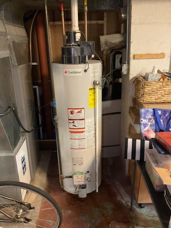 Provided estimate for replacement of 12-year-old Lochinvar water heater exhibiting active leaking and visible corrosion staining on lower exterior. Unit has been experiencing chronic leakage for extended period, requiring immediate replacement to prevent further water damage to basement area and property.
