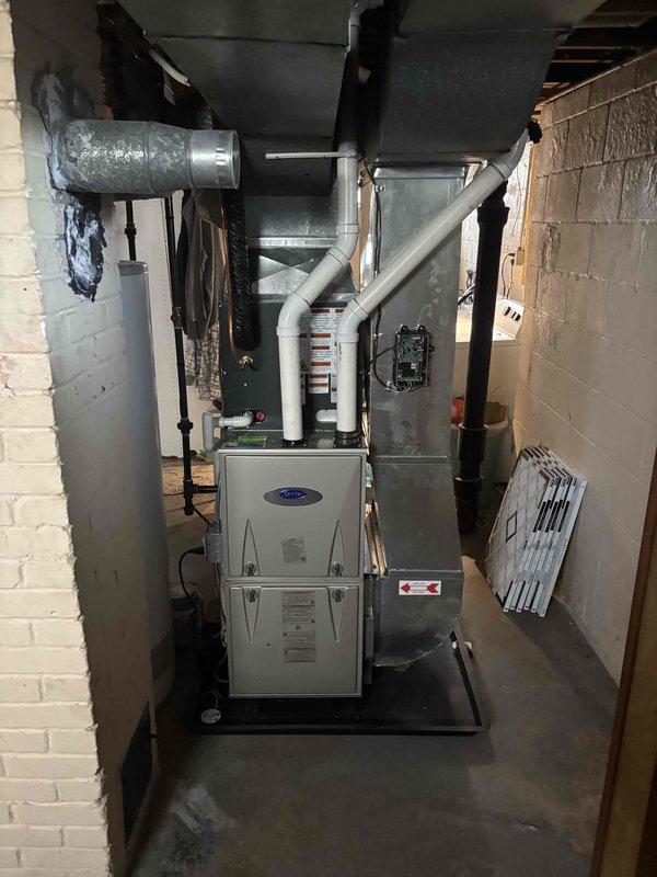 Completed full air conditioning system replacement including outdoor condenser unit and indoor air handler components. Installed new Carrier equipment on existing concrete pad with proper electrical disconnect, refrigerant line sets, and condensate drainage. Connected system to existing gas furnace in basement mechanical room, ensuring proper ductwork integration and airflow configuration.