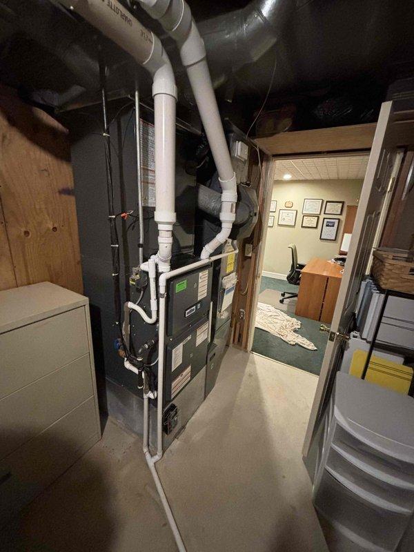Successfully completed full HVAC system replacement in basement utility area. Installed new furnace unit with proper clearances and ventilation, including complete PVC condensate drain and vent piping configuration with multiple elbows and joints. Connected flexible silver ductwork to new air handler, ensuring proper airflow distribution throughout the structure. All installations meet manufacturer specifications and building code requirements, with organized piping layout and professional finish work completed.