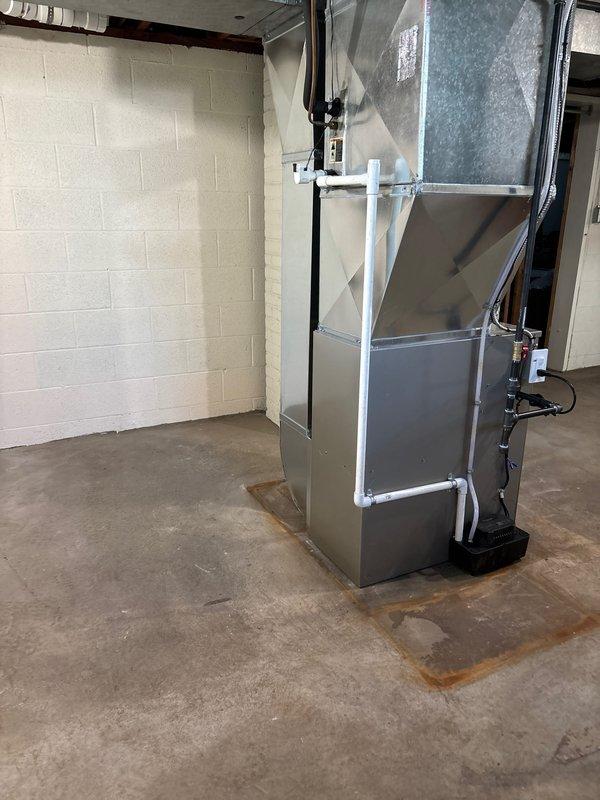 Completed full furnace installation in residential basement utility room. Installed Carrier brand furnace unit with complete ductwork system, including vertical and horizontal duct connections to existing infrastructure. Connected all necessary PVC venting pipes, gas lines, electrical components, and control systems to ensure proper operation. System tested and verified operational upon completion.