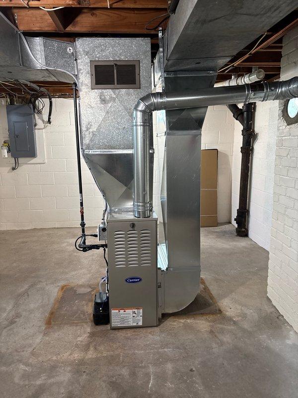 Completed full furnace installation in residential basement utility room. Installed Carrier brand furnace unit with complete ductwork system, including vertical and horizontal duct connections to existing infrastructure. Connected all necessary PVC venting pipes, gas lines, electrical components, and control systems to ensure proper operation. System tested and verified operational upon completion.