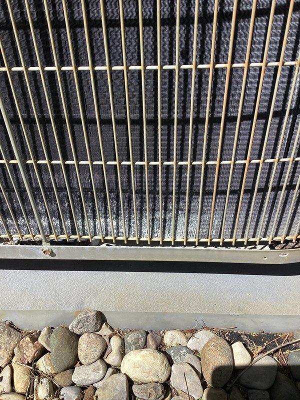 # Carrier AC Maintenance and Cleaning

Responded to service call for 10-year-old Carrier air conditioning system experiencing reduced cooling performance. Upon arrival, performed visual inspection of outdoor condenser unit and identified significant debris accumulation affecting system efficiency.

Condenser coil fins showed substantial dirt, dust, and organic matter buildup throughout the heat exchanger assembly, particularly concentrated in lower sections. External grille and protective panels exhibited heavy contamination with mold, mildew, and environmental debris covering approximately 60-70% of accessible surfaces. Vegetation growth observed at unit base, with weeds encroaching on equipment foundation.

Performed comprehensive condenser coil cleaning using appropriate cleaning solutions and techniques to remove accumulated dirt and biological growth from fins and coil surfaces. Cleaned external cabinet panels and protective grilles to remove mold, mildew, and surface contaminatio