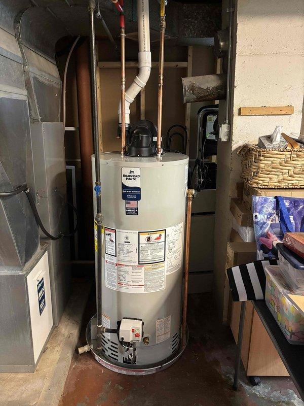 Completed installation of a 50-gallon Bradford White power vent natural gas water heater with 6-year warranty. All plumbing connections were made using copper piping with proper fittings, PVC venting was installed per manufacturer specifications, and the unit was secured and tested for proper operation. The installation included connection to existing gas supply, cold water inlet with isolation valve, hot water outlet, temperature and pressure relief valve discharge piping, and verification of all safety controls and venting systems for code compliance.