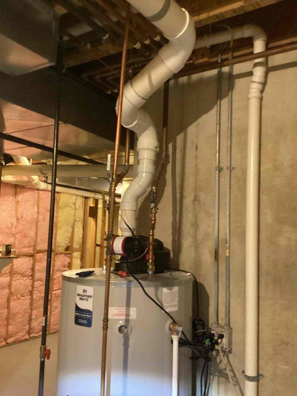 Responded to water heater leak at bottom of unit causing drip pan overflow. Upon inspection, confirmed Bradford White water heater manufactured in 2022 with partial replacement completed in 2024 under limited warranty coverage. Assessed severity of leak originating from tank base and determined internal tank failure requiring full unit replacement. Documented existing plumbing configuration including copper supply lines, circulation pump assembly, and PVC venting system for replacement specifications. Advised client that tank integrity compromise cannot be repaired and complete water heater replacement is necessary to resolve issue.