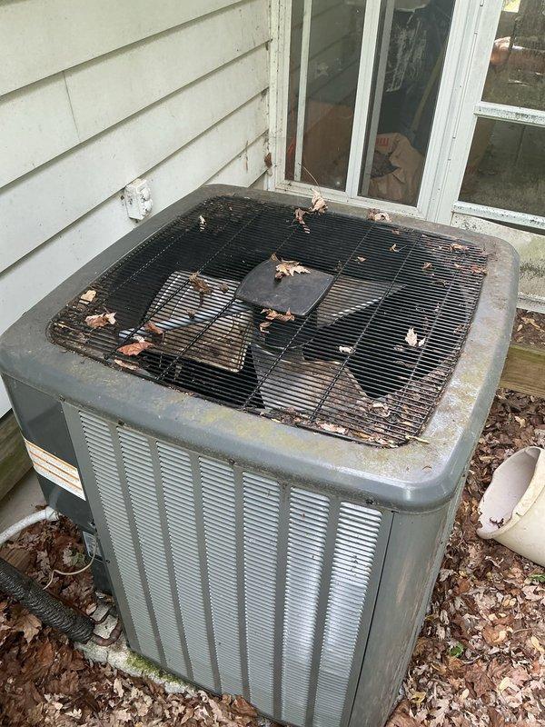Completed annual cooling maintenance on residential air conditioning system. Removed significant accumulation of leaves and organic debris from condenser unit's top grille and surrounding area. Cleaned outdoor unit exterior surfaces, removing dirt and weathering buildup from metal casing. Inspected and cleaned return air vent grille, addressing dust accumulation and cobweb buildup between louvers. Performed standard AC tune-up procedures including system performance verification. Unit operational and ready for cooling season.