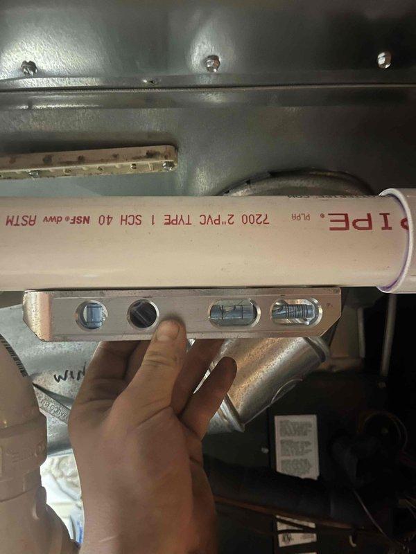 Completed inspector-requested corrections to high-efficiency furnace venting system. Corrected 2' section of level vent pipe to achieve minimum 1/4" per foot upward slope from furnace to termination point, installed proper support brackets at required 4' intervals throughout approximately 5' of PVC vent piping, and documented all corrections with photographs for remote inspection approval.