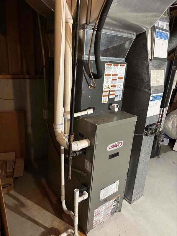 Completed full air conditioning system replacement including outdoor condensing unit installed on concrete pad with proper electrical disconnect and indoor air handler integrated with existing Lennox furnace system. All refrigerant lines, condensate drainage, and electrical connections properly installed and tested. System commissioned and verified operational with appropriate airflow and cooling performance.
