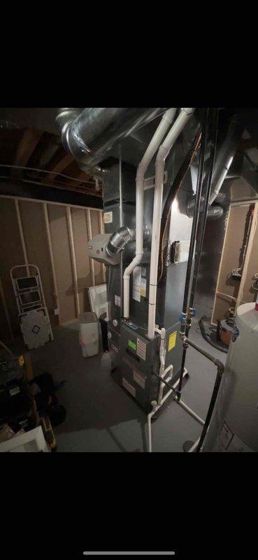 Completed full furnace and air handler installation in basement mechanical room. Installed new HVAC system including air handler unit with proper refrigerant line connections, ductwork integration using flexible and rigid metallic ducts, and white PVC condensate drainage piping. System positioned vertically in unfinished basement space with all electrical connections, ventilation infrastructure, and manufacturer specifications verified. All components properly mounted, secured, and tested for operational readiness.