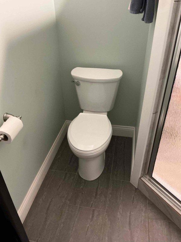 Returned to property to replace previously installed toilet with Gerber Viper model as quoted. Successfully removed existing two-piece toilet, installed new Gerber Viper unit, and verified proper function and seal. Completed installation in bathroom with light green walls and gray tile flooring, ensuring all connections were secure and leak-free.