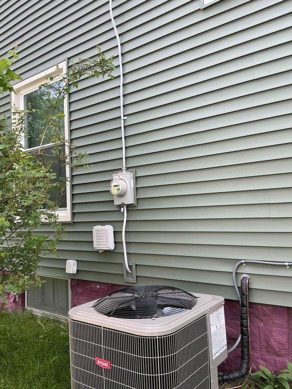 Responded to service request for electrical assessment in attic space. Upon arrival, conducted exterior inspection of existing electrical service and meter location to evaluate current capacity and available circuits for potential attic electrical addition. Proceeded to attic space and performed comprehensive evaluation of existing conditions, including structural layout, accessibility, and proximity to existing electrical distribution. Documented current wiring configuration, including visible Romex cable and ceiling-mounted electrical fixture with standard white porcelain socket. Assessed wooden joist structure and plywood decking to determine optimal routing path for new electrical service. Photographed existing electrical infrastructure both at exterior service entrance and within attic space to provide documentation for electrical load calculation and circuit planning. Evaluated feasibility of extending electrical service to attic area, considering code compliance requirements, pr