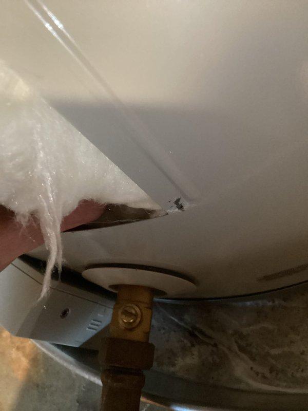 Responded to report of water accumulation in drain pan beneath two-year-old Bradford White water heater model WT 05-2030. Upon arrival, inspected unit and found active water presence in pan while heater continued to operate and produce hot water. Removed insulation jacket to access and examine temperature and pressure relief valve, drain valve, and supply line connections for signs of leakage. Conducted thorough visual inspection of all plumbing connections, fittings, and tank exterior to identify source of water discharge. Documented conditions with photographs showing valve assembly area and drain pan for warranty and service record purposes. Unit remains operational pending determination of leak source and recommended repairs.