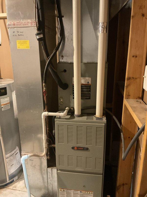 Provided estimate for installation of performance-enhancing refrigerant additive to improve system efficiency on existing Trane split system. Documented current equipment condition including outdoor condensing unit on concrete pad with proper clearances and indoor furnace/air handler in basement mechanical room with associated ductwork and venting.