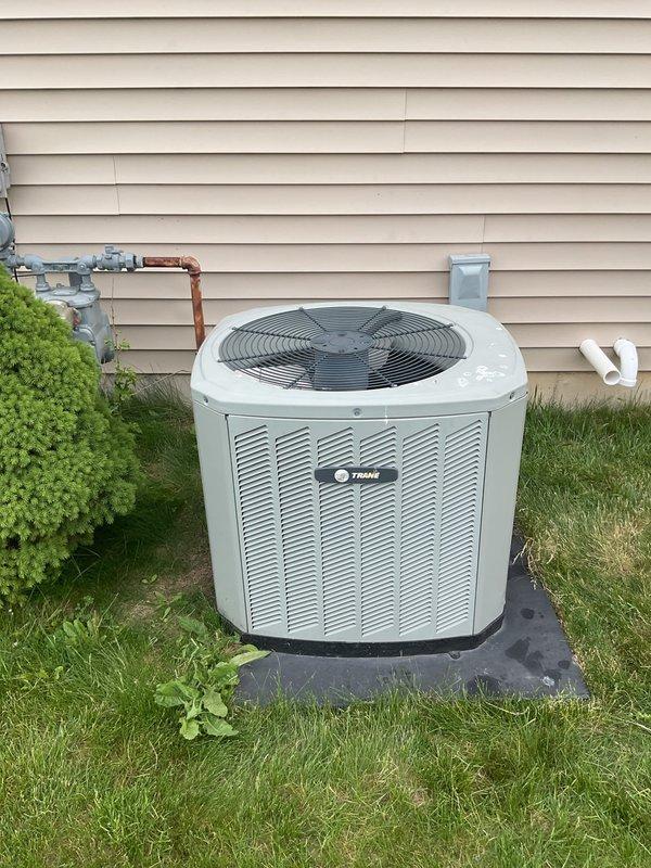 Provided estimate for installation of performance-enhancing refrigerant additive to improve system efficiency on existing Trane split system. Documented current equipment condition including outdoor condensing unit on concrete pad with proper clearances and indoor furnace/air handler in basement mechanical room with associated ductwork and venting.